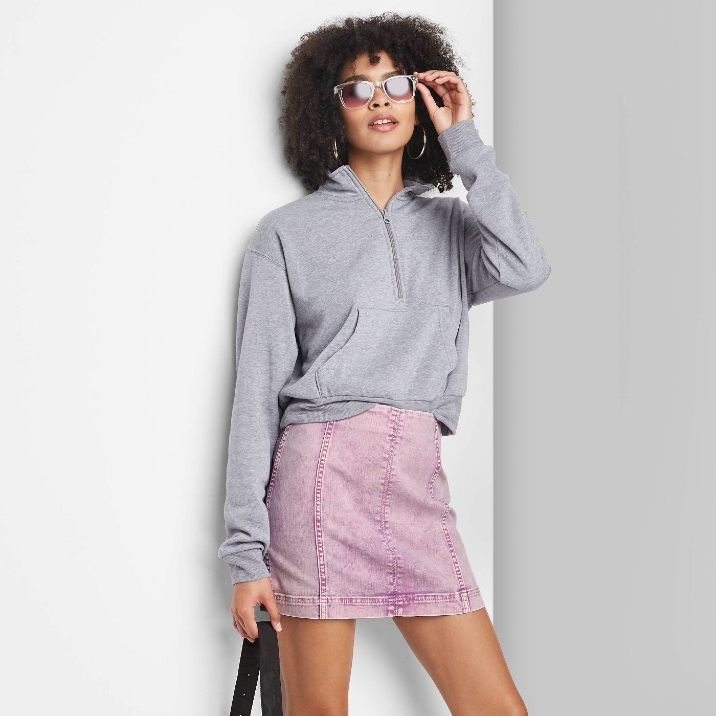 Model wearing pink seamed denim skirt, stops mid thigh