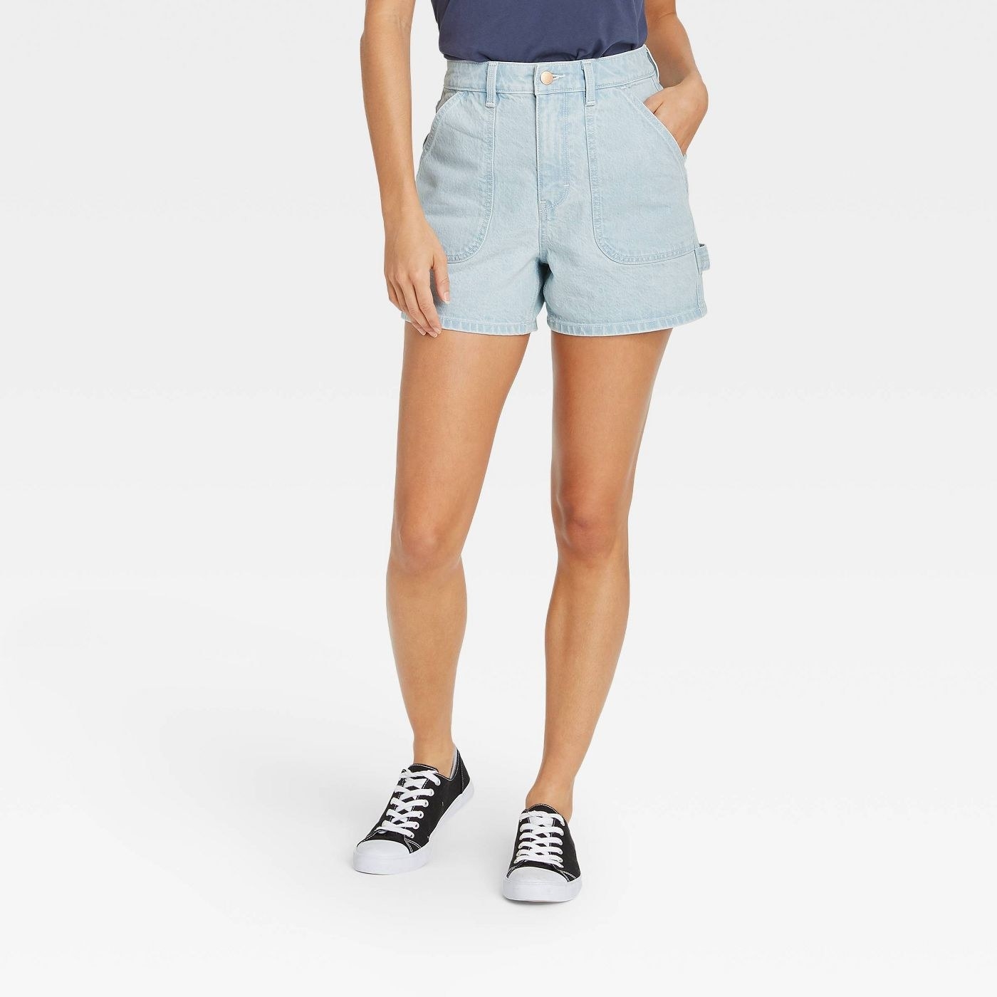 Model wearing light denim shorts with strap on right side 