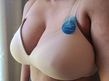 A reviewer wearing the bra in a nude color 