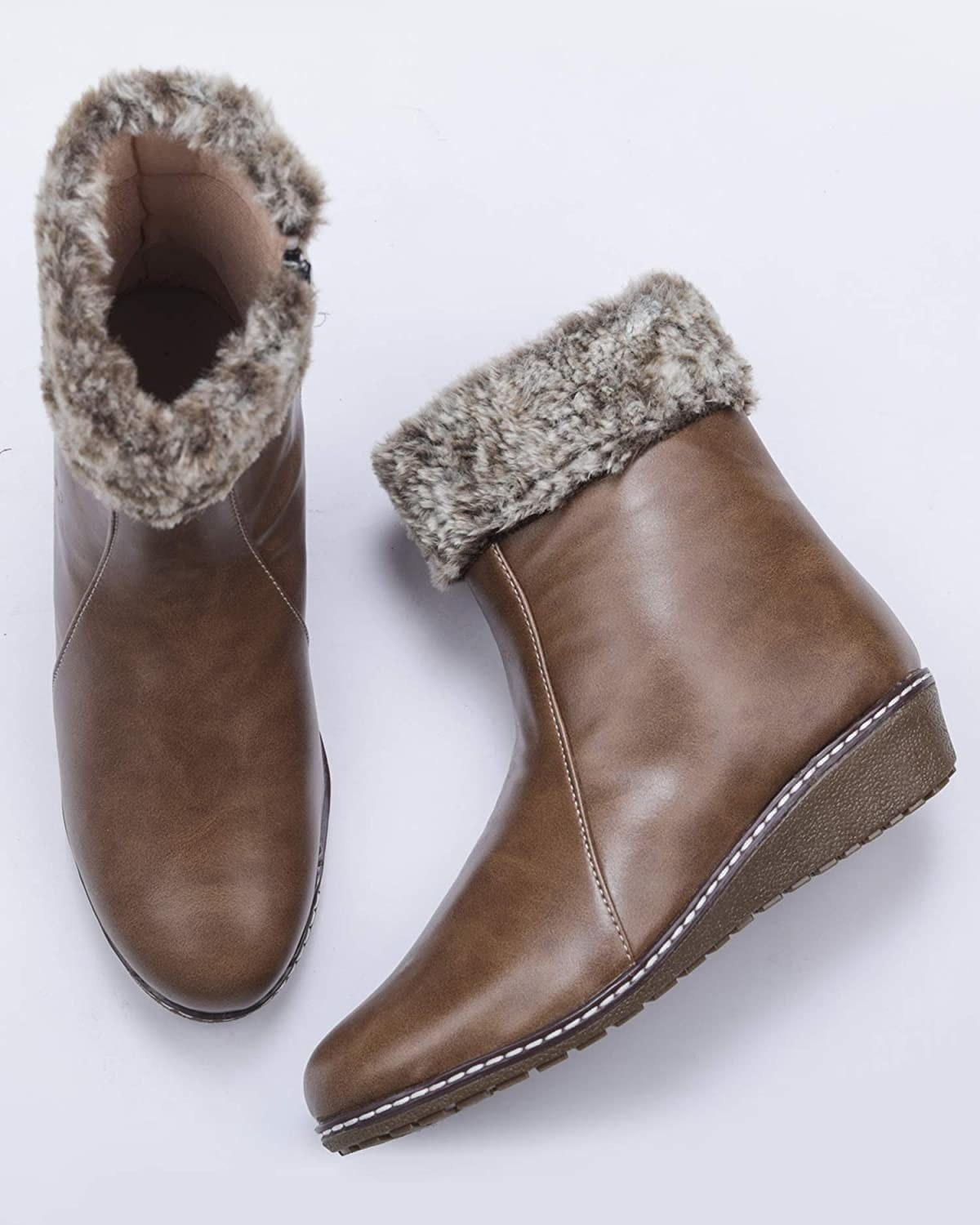 A pair of brown boots with fur on them 