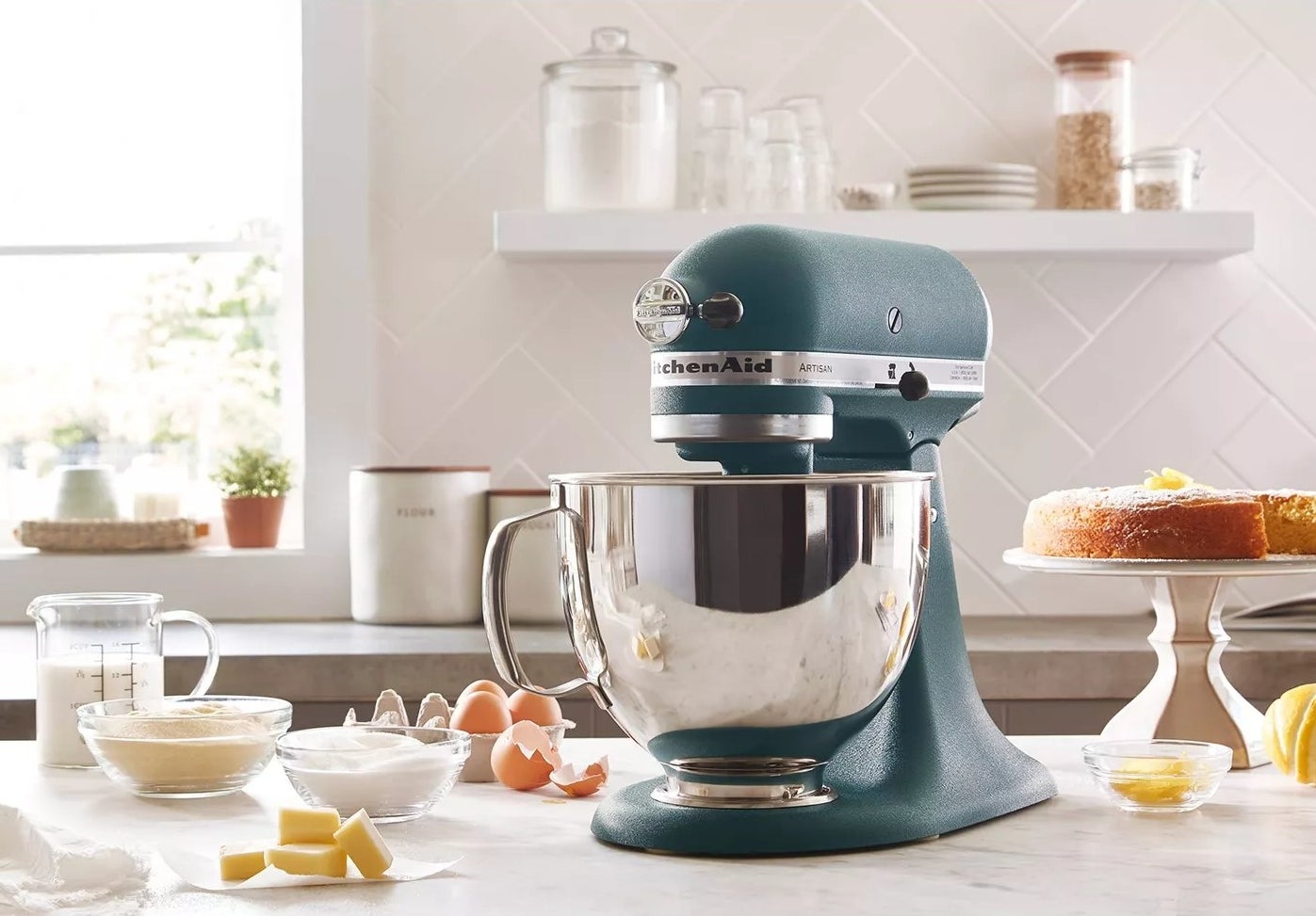 The pebbled hunter green stand mixer on a kitchen counter mixing dough