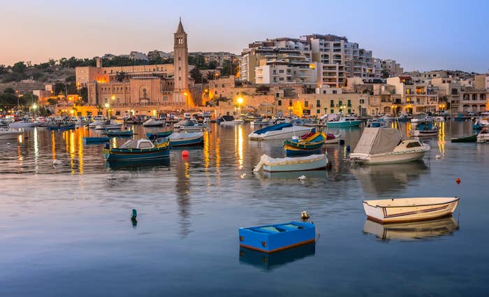 maltese town in the evening with boats on the water