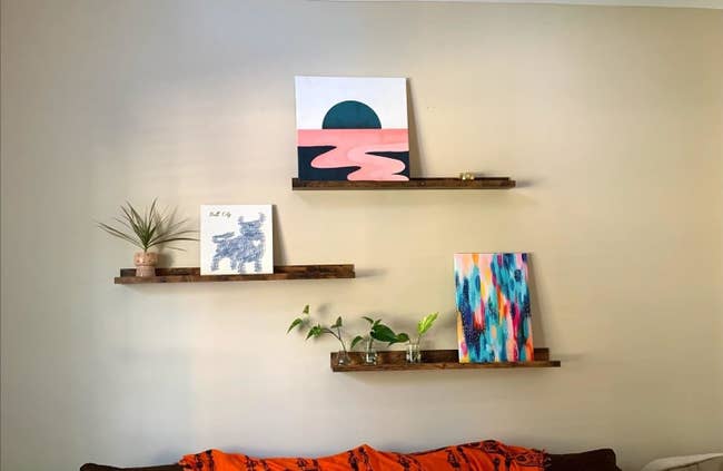 the floating shelves in a living room above a couch