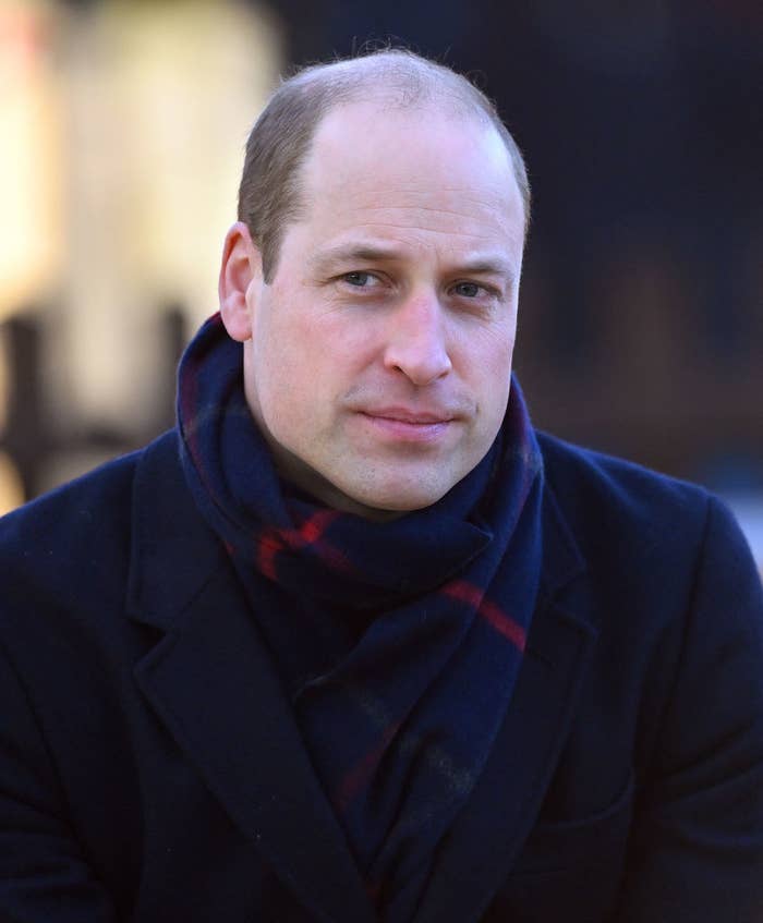 A balding Prince William in a coat and scarf