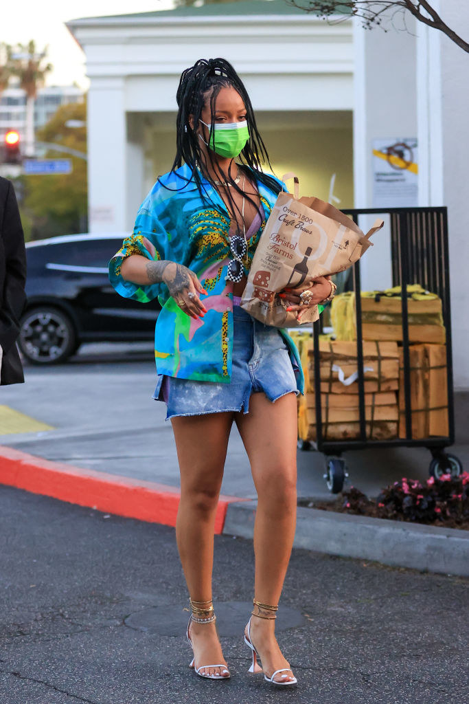 wearing a green mask and a short skirt and holding a grocery bag
