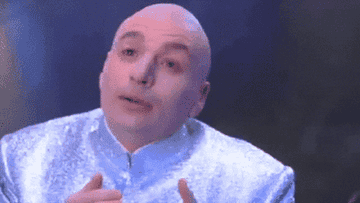 A gif of Doctor Evil from Austin Powers doing faux sign language and mouthing I love you, you complete me