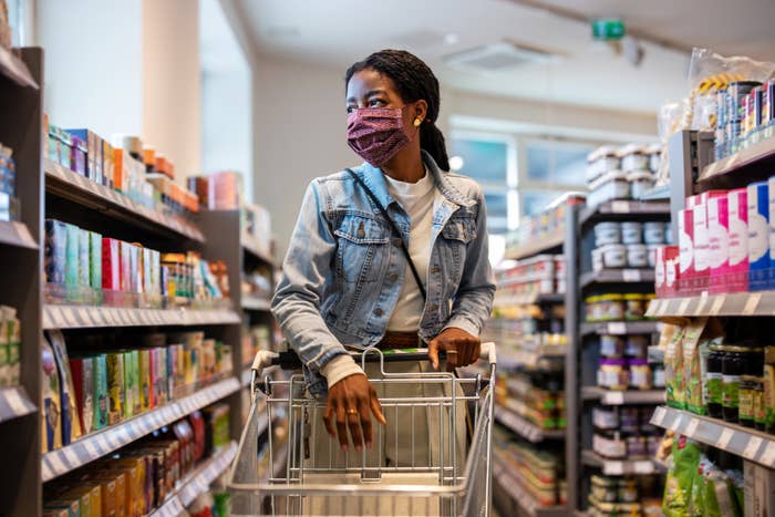 woman grocery shopping in a mask