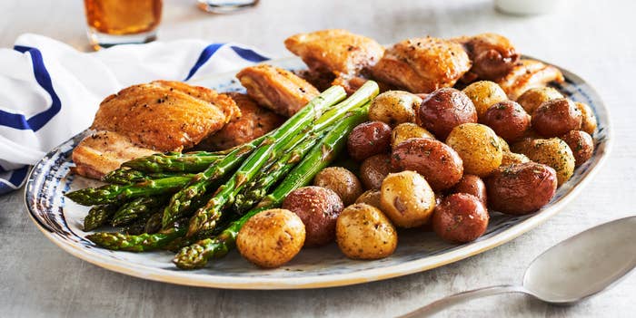 A big plate of sheet pan–roasted whole seasoned little potatoes, asparagus, and chicken.