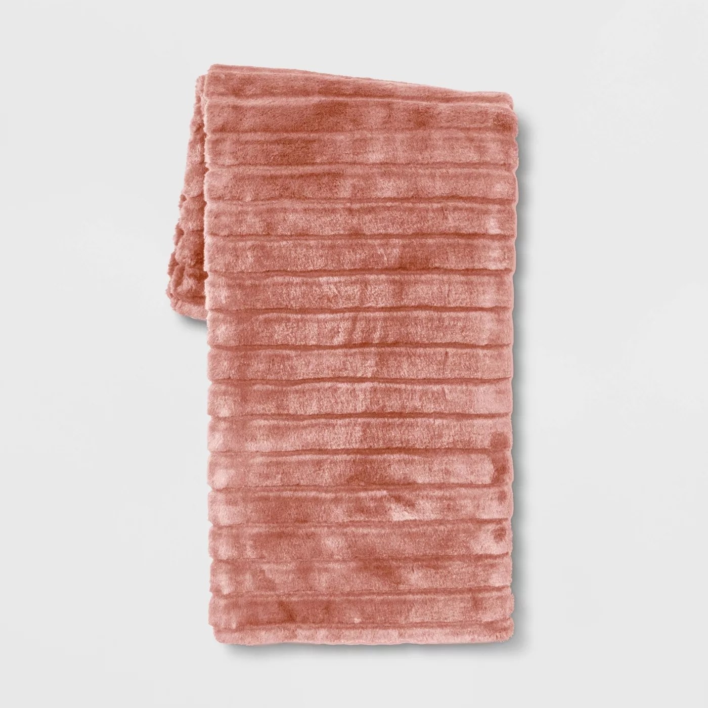 The coral-colored faux fur throw with ribbed texture on one side
