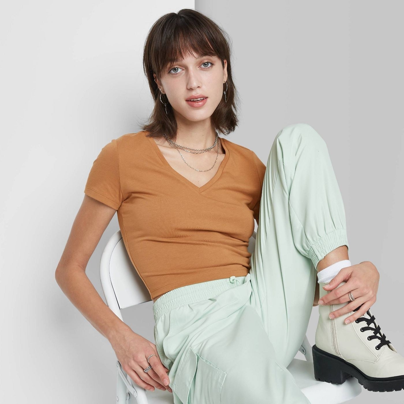 Model wearing mustard yellow shirt, stops at the waist