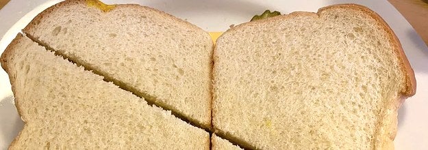 Two sandwiches cut diagonally where the halves are wildly different sizes
