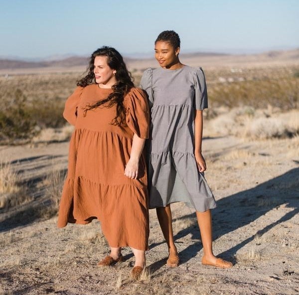 two models wearing the same short-sleeved midi dress with a tiered skirt in gingham and terracotta 