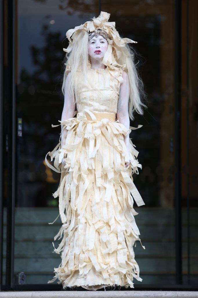 Gaga wearing a dress that looks like it&#x27;s made of scraps of fabric along with white face and arm paint