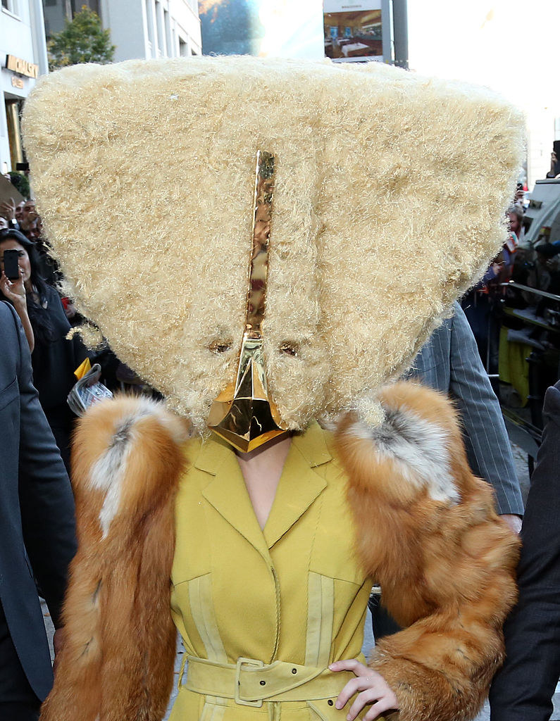 Gaga in a giant triangular headpiece that looks like it&#x27;s made of fur