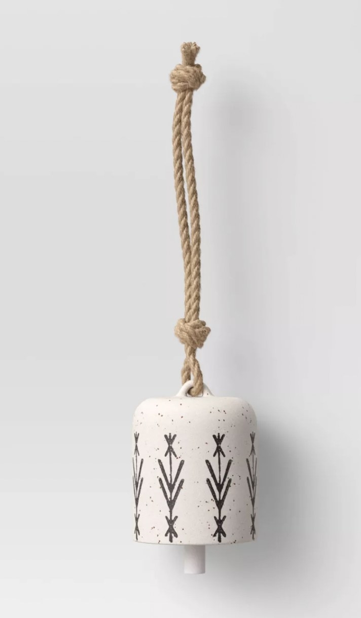 a white ceramic wind chime attached to a rope for hanging