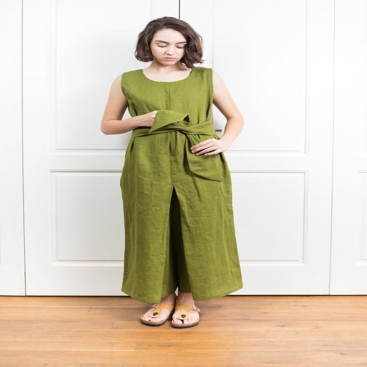 front view of a model tying a green jumpsuit