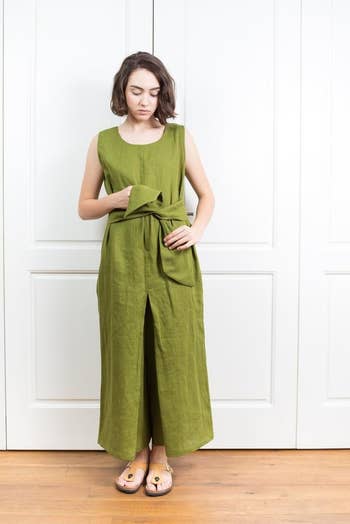 front view of a model tying a green jumpsuit