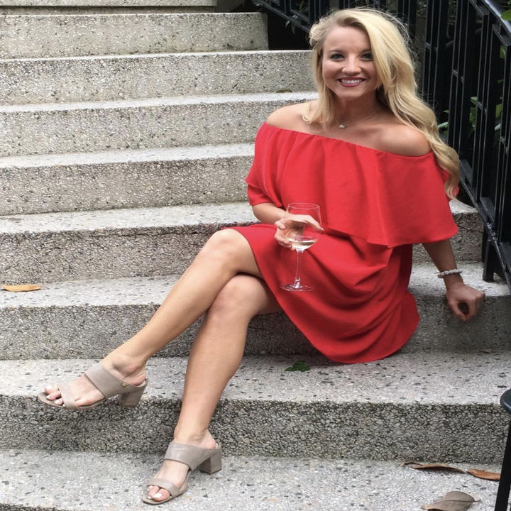 reviewer wearing the red off-shoulder dress