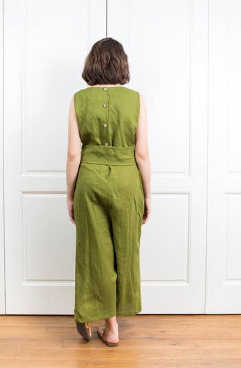 back view of the same model showing the jumpsuit has three buttons