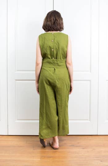 back view of the same model showing the jumpsuit has three buttons