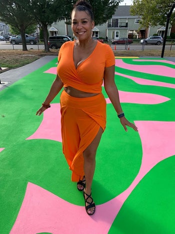 image of reviewer wearing the orange Vetior cross wrap crop top with matching orange skirt