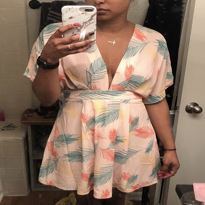 reviewer wearing the V-neck pink and green dress 