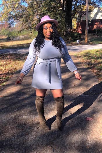 plus size reviewer wearing the grey prettygarden tie waist dress with knee high suede boots