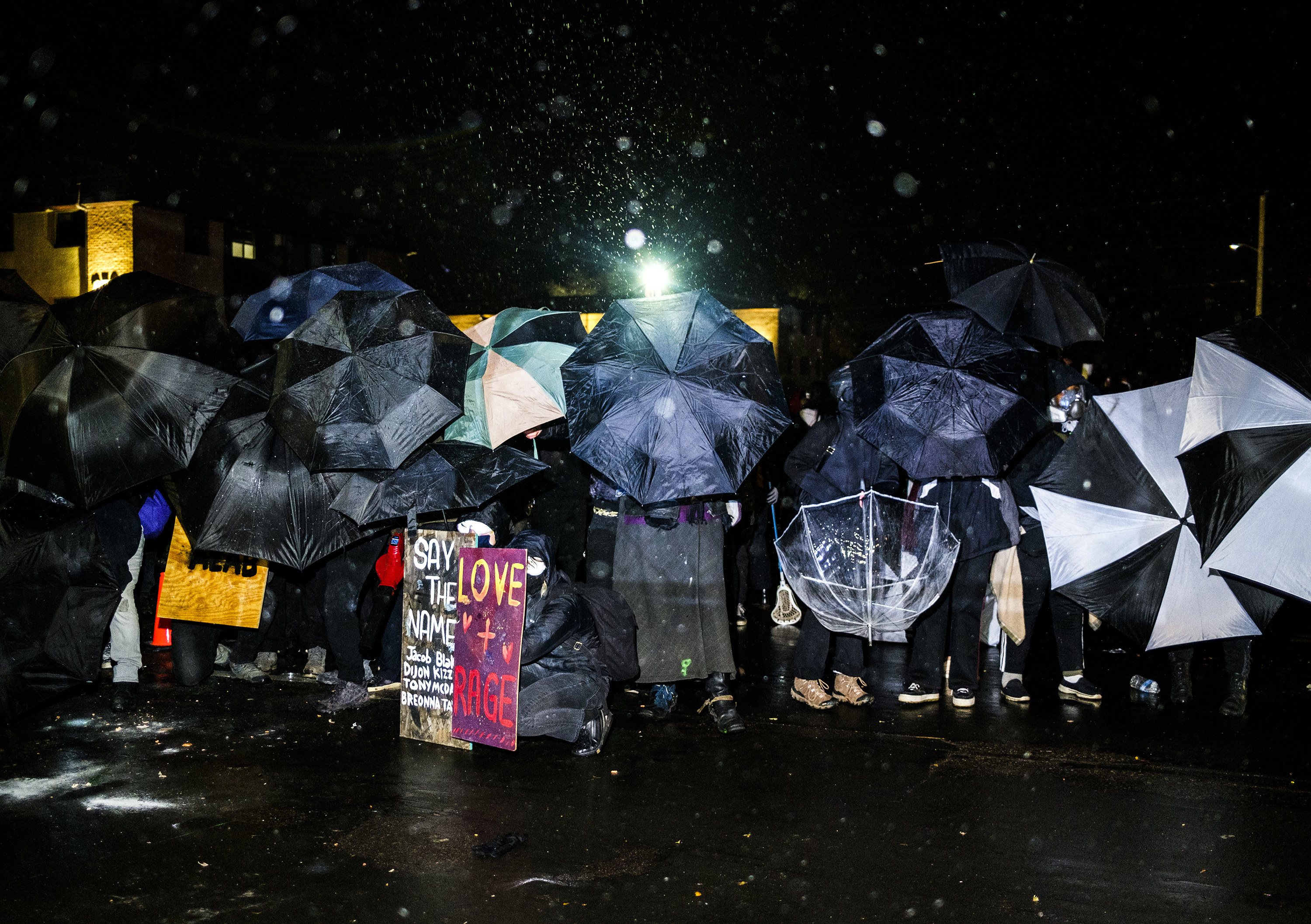 Protesters shield themselves with umbrellas