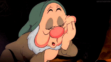 A gif of Sleepy from Snow White falling asleep on his hand