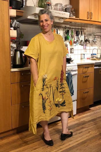 a reviewer wearing the embroidered midi dress in yellow 