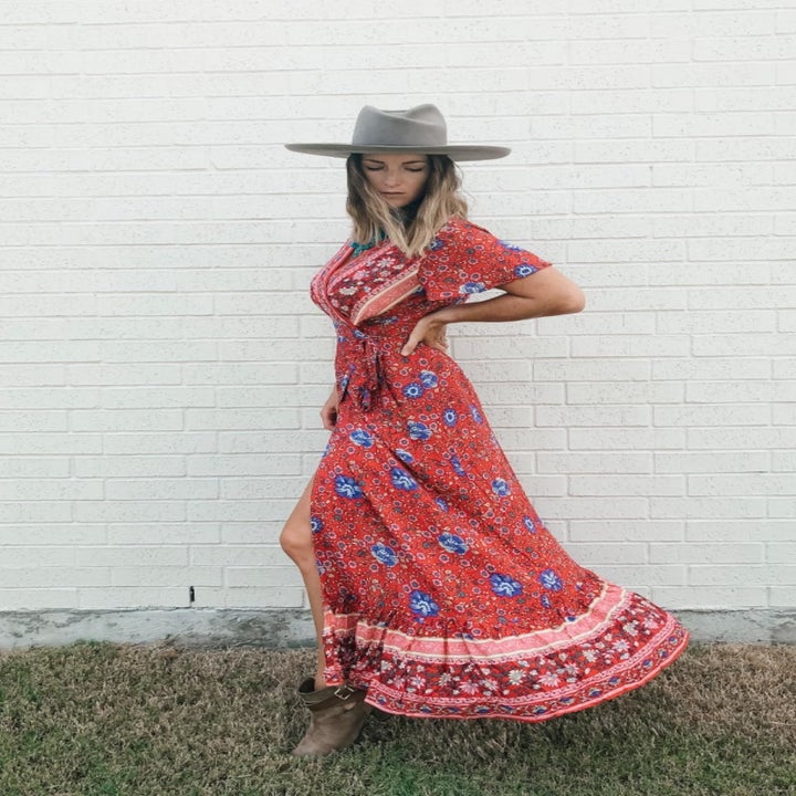 a reviewer wearing the red dress with a hat