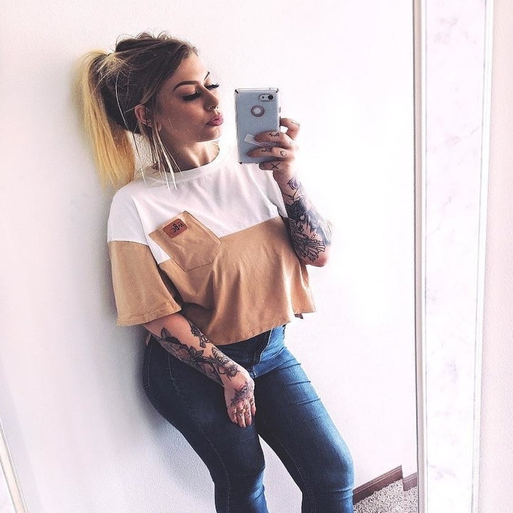 a reviewer wearing the top in apricot and white