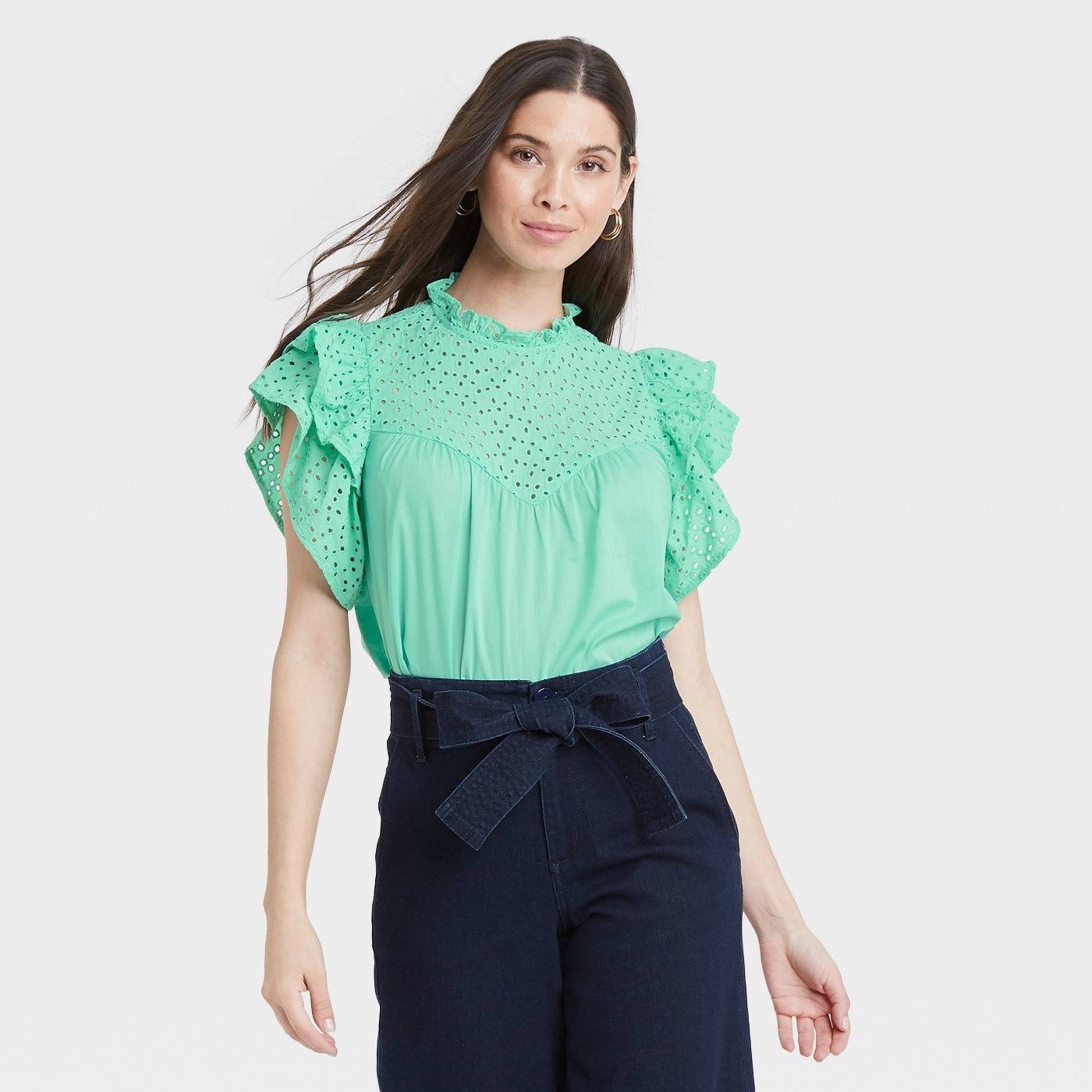 Model wearing sea green top