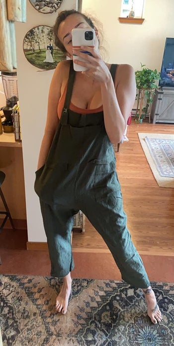 a reviewer wearing the overalls in army green