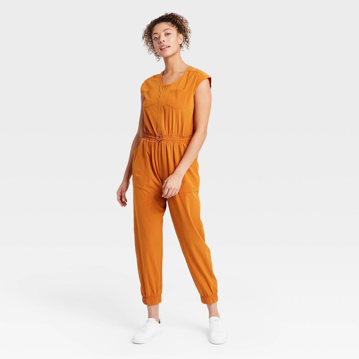 Model wearing mustard yellow jumpsuit cuffed at the ankle