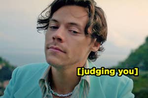 Harry Styles narrowing his eyes in the "Golden" music video labeled "[judging you]"