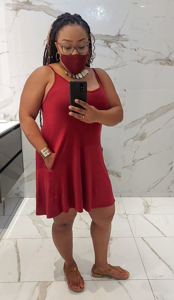 a reviewer mirror selfie of someone in the red tank dress with a matching face mask 
