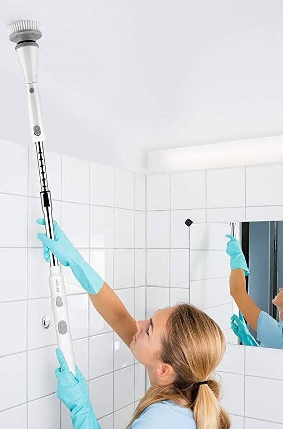 a person using the scrubbing wand on a ceiling 