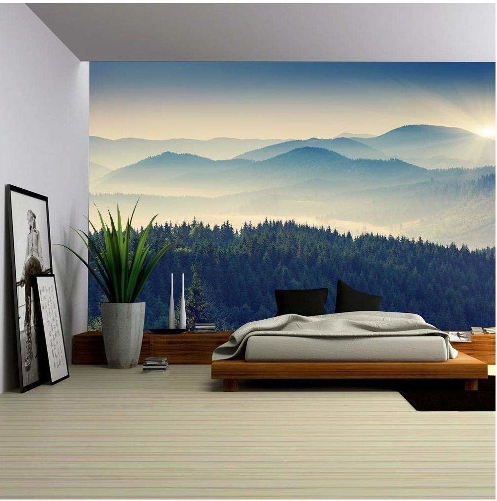 the mountain mural with a pine forest and mountain landscape in the foreground on a bedroom wall