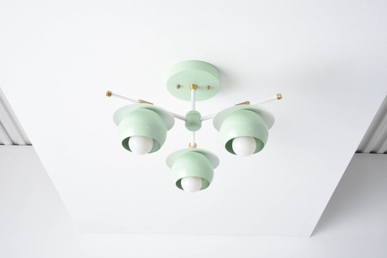 the mint green light with three bulbs hanging from the ceiling 
