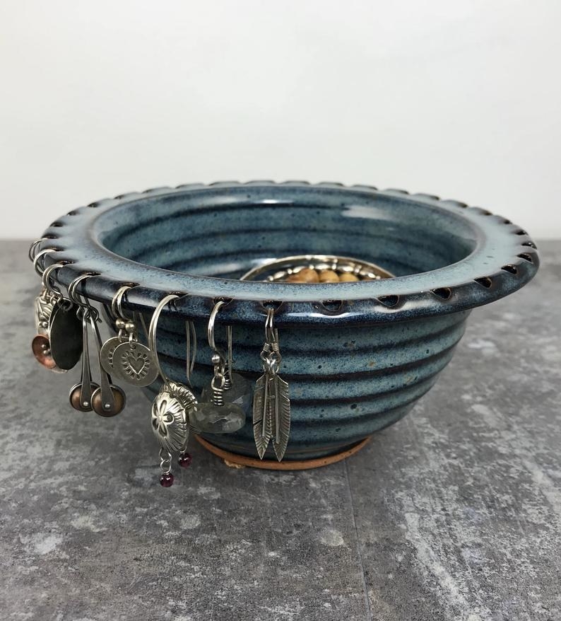 a denim blue bowl with holes on the rim to hold earrings 