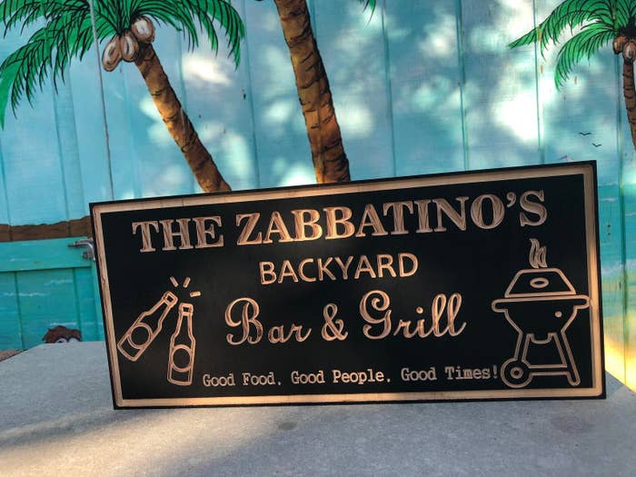 a wood sign that reads, "The Zabbatino's Backyard & Grill, Good Food, Good People, Good Times"