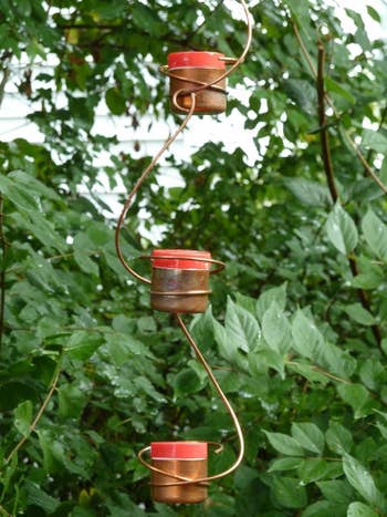 Three cylindrical feeders hanging vertically