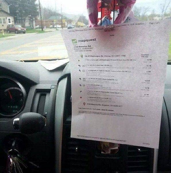 A printed out mapquest map hanging on a rearview window