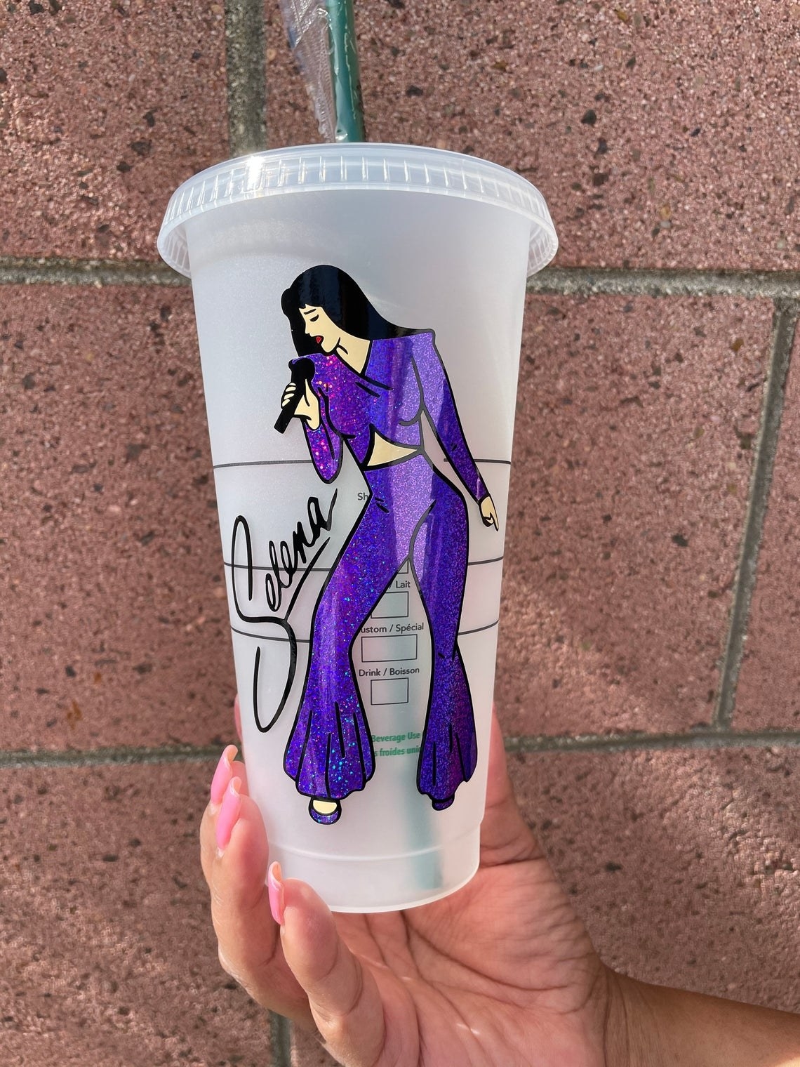 A hand holding the Selena Inspired Starbucks Reusable Cup
