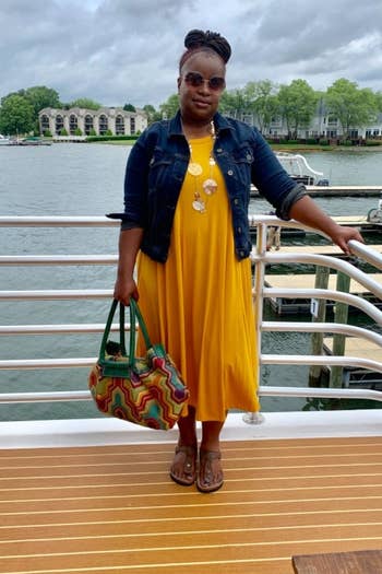 reviewer wearing the dress in yellow with a denim jacket 