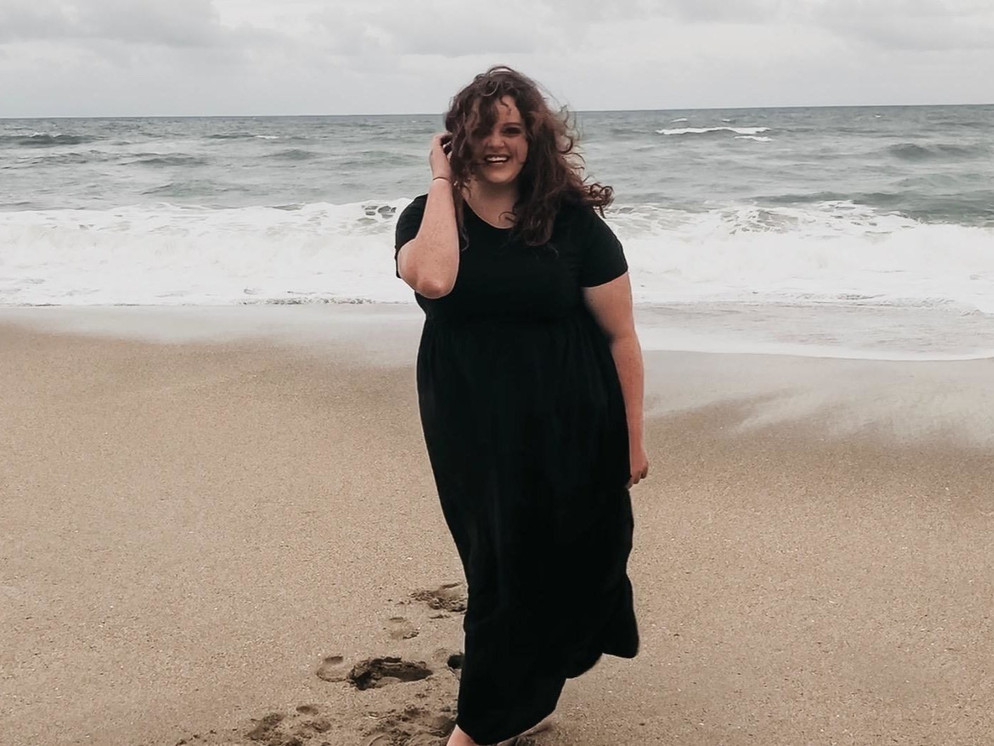 reviewer wearing the black maxi dress on the beach 
