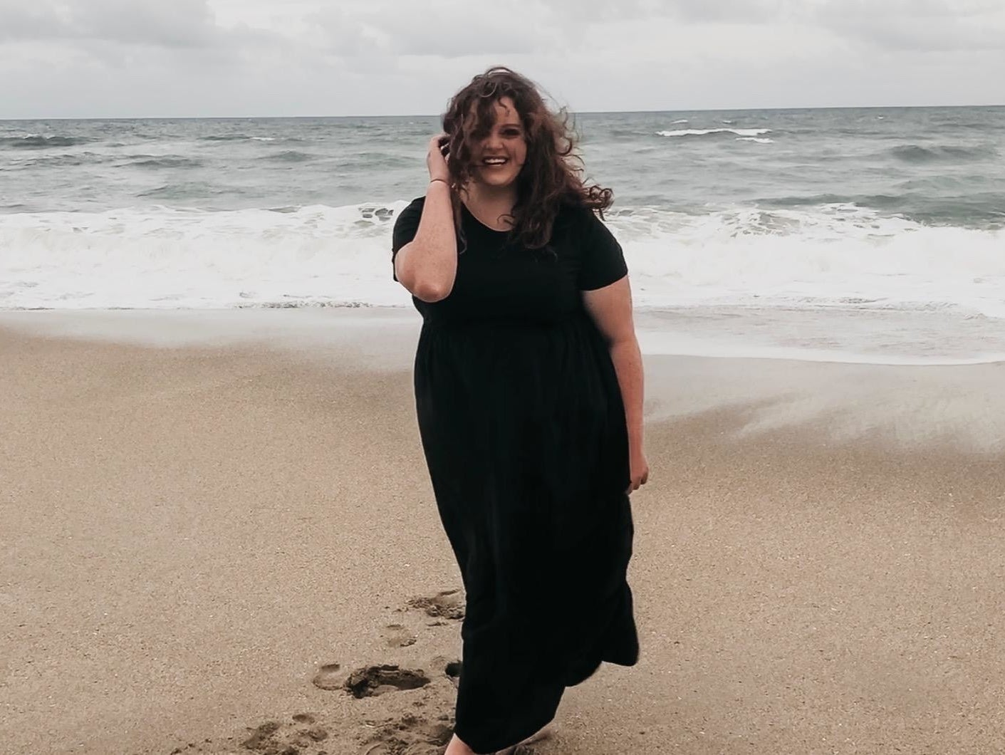 reviewer wearing the black maxi dress on the beach 