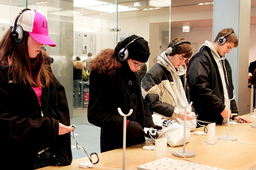 Four people playing iPods in the Apple Store