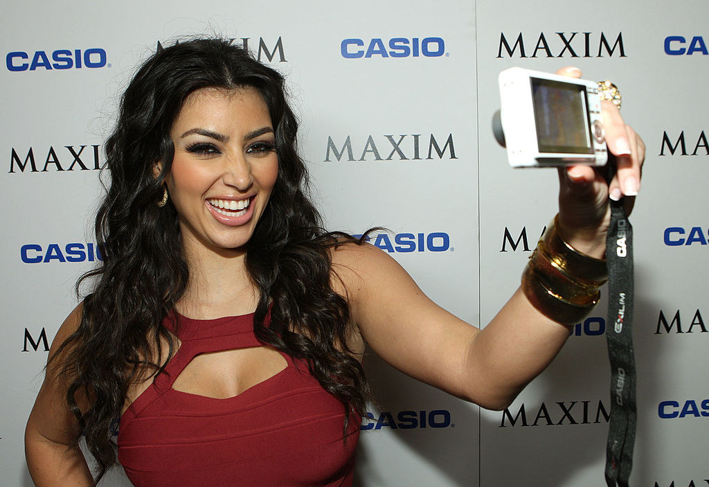 Kim Kardashian at the Maxim Style Awards taking a selfie with a digital camera